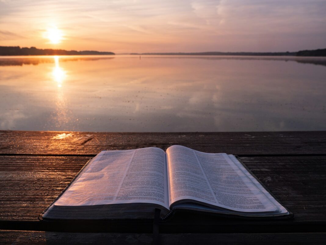 Bible on top of table and body of water