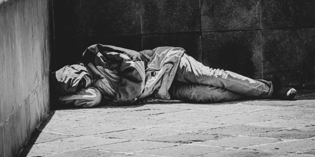 Dramatic black and white photograph highlighting urban homelessness and social issues.