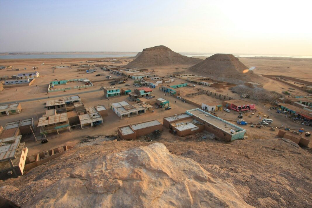 an aerial view of a desert town with a mountain in the background