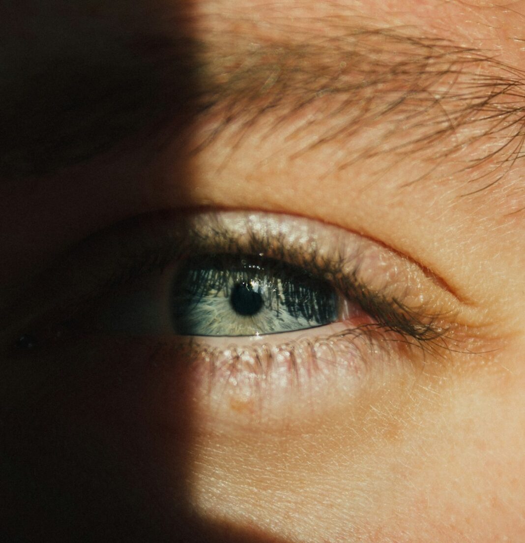 Close-up of a blue human eye with dramatic lighting