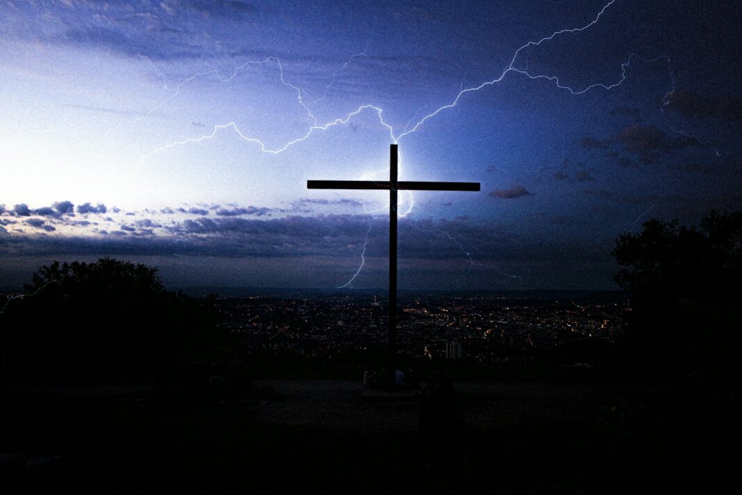 silhouette of cross under cloudy sky during night time
