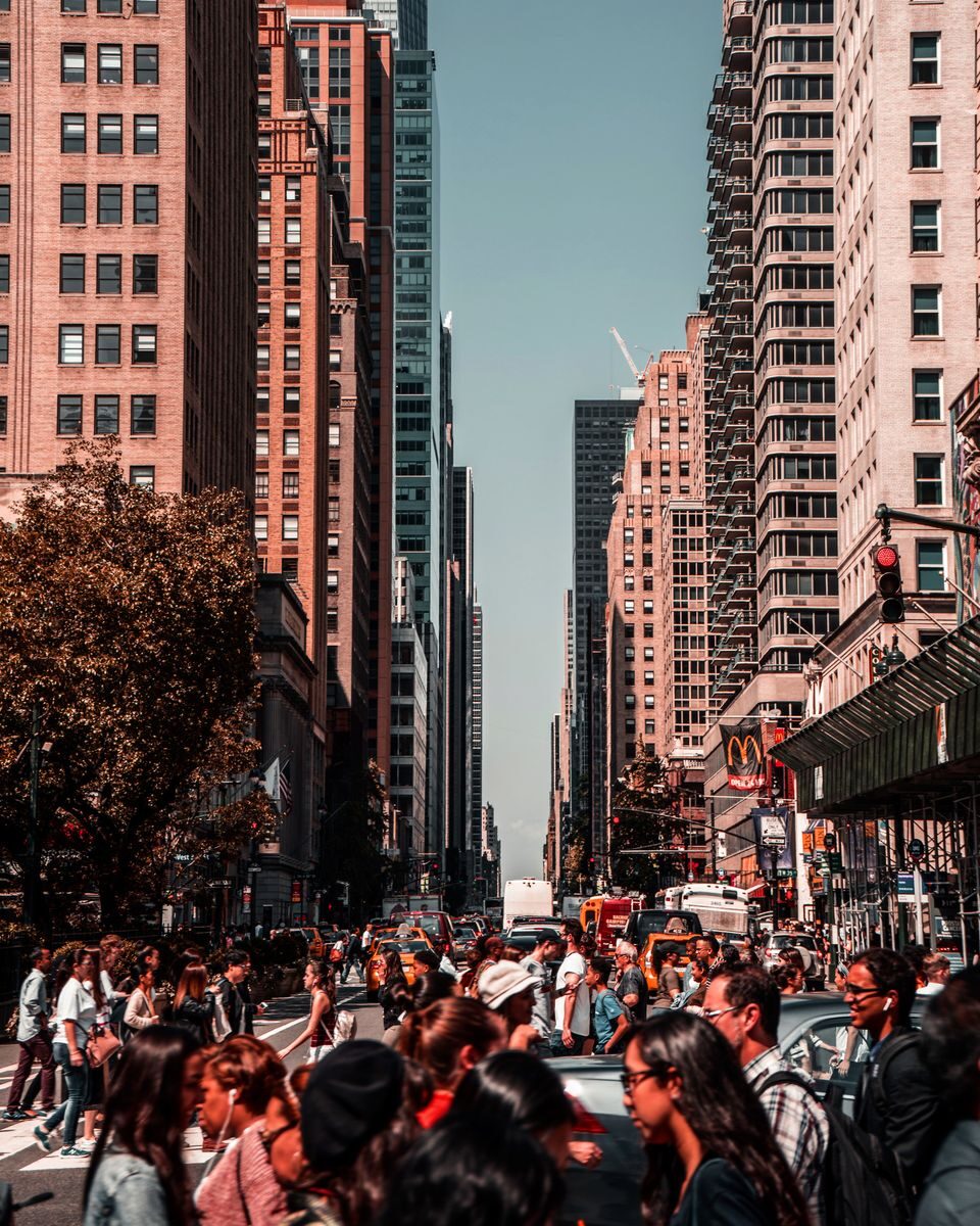 Vibrant daylight scene capturing a crowded street in New York City amidst towering skyscrapers.